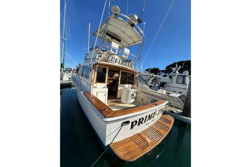 Slide: The Image of 1985 Egg Harbor 33 Sedan boat docked, featuring wooden deck and upper helm. - 8