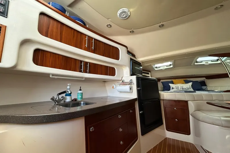Slide: The Image of 2007 Grady-White Express 360 interior with kitchenette, seating, and storage cabinets. - 17