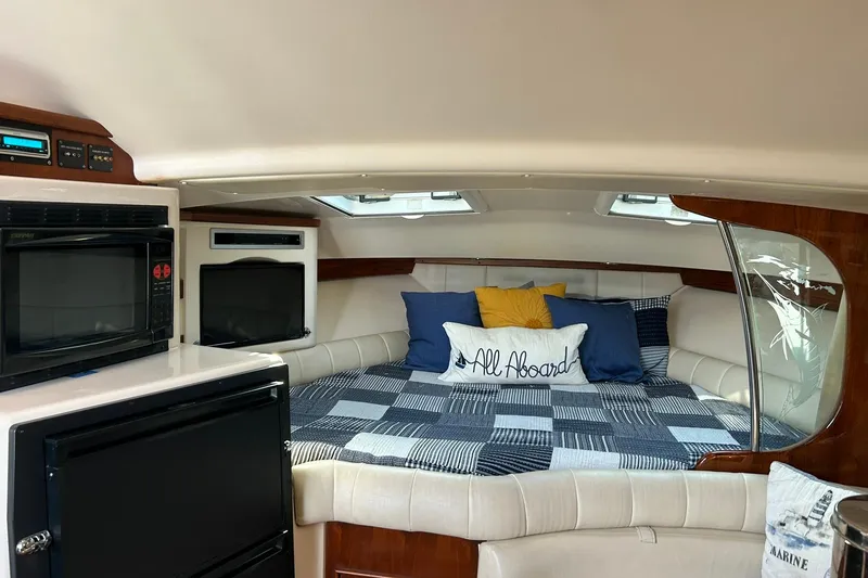 Slide: The Image of 2007 Grady-White Express 360 cabin interior with bed, microwave, and TV. - 22