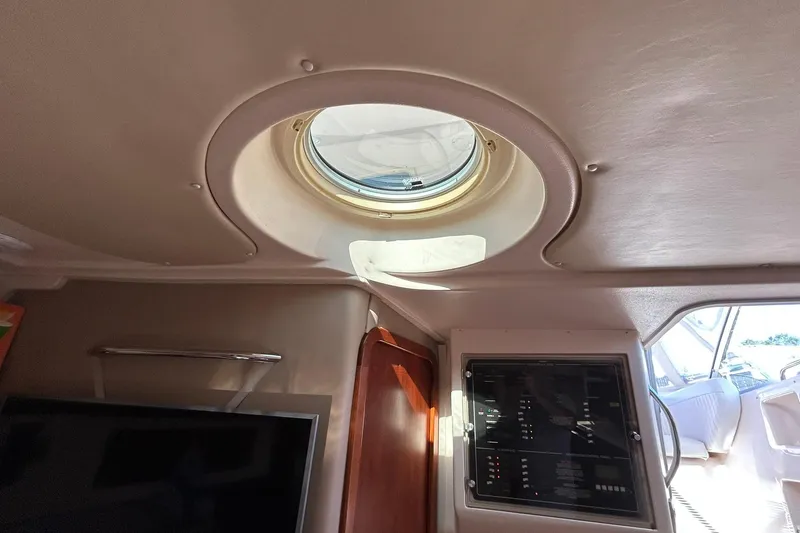 Slide: The Image of Interior view of 2007 Grady-White Express 360 boat, featuring a porthole and control panel. - 32