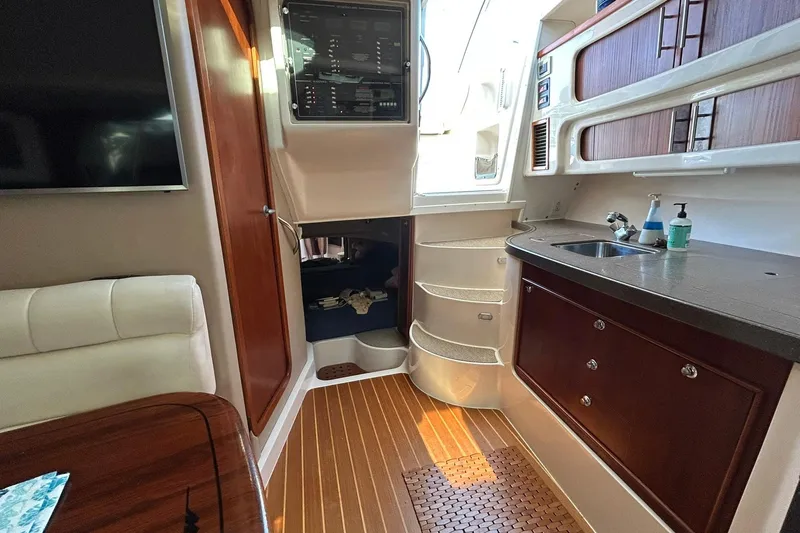 Slide: The Image of 2007 Grady-White Express 360 interior with kitchenette, seating, and wooden flooring. - 49