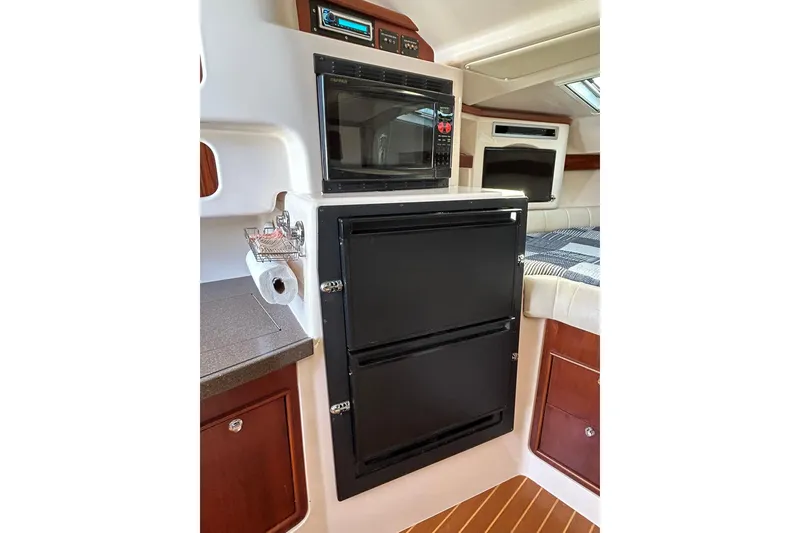 Slide: The Image of 2007 Grady-White Express 360 interior with microwave, fridge, and cozy cabin space. - 58