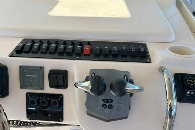 Slide: The Image of Control panel of a 2007 Grady-White Express 360 boat with switches and throttle levers. - 68