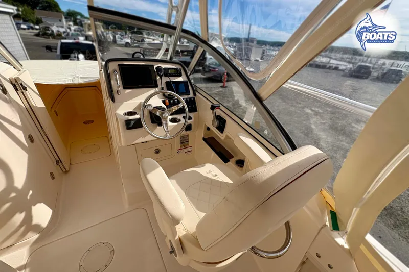 Slide: The Image of 2019 Grady-White Freedom 235 boat interior with steering wheel and dashboard controls. - 8