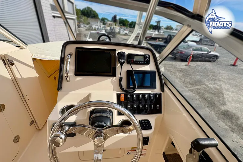 Slide: The Image of 2019 Grady-White Freedom 235 boat dashboard with steering wheel and navigation controls. - 9