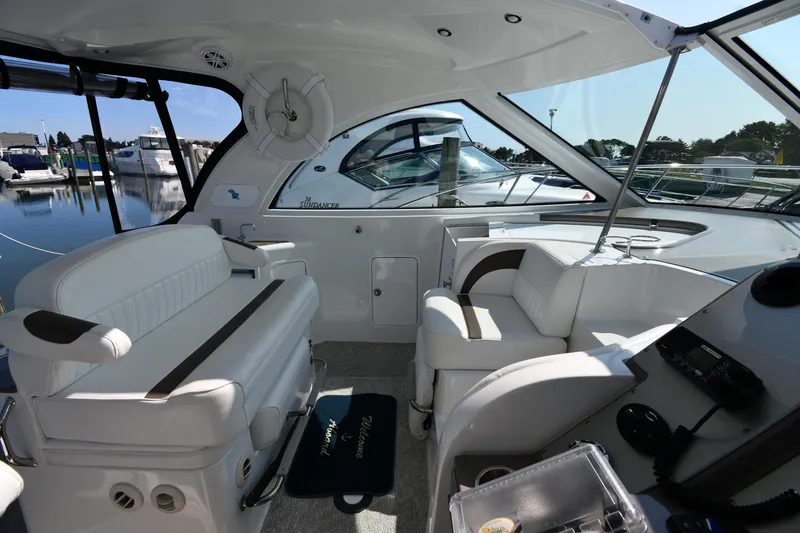 Slide: The Image of 2010 Cruisers Yachts 390 Sports Coupe interior with white seating and helm, docked at marina. - 19