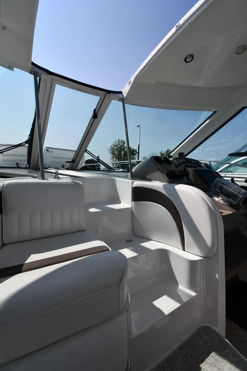 Slide: The Image of 2010 Cruisers Yachts 390 Sports Coupe interior with seating and helm, under clear blue sky. - 34
