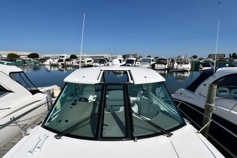 Slide: The Image of 2010 Cruisers Yachts 390 Sports Coupe docked in a marina, surrounded by other boats. - 7