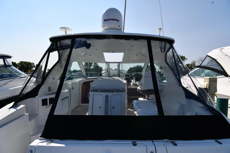 Slide: The Image of 2010 Cruisers Yachts 390 Sports Coupe, rear view, docked, with clear canopy and modern design. - 9