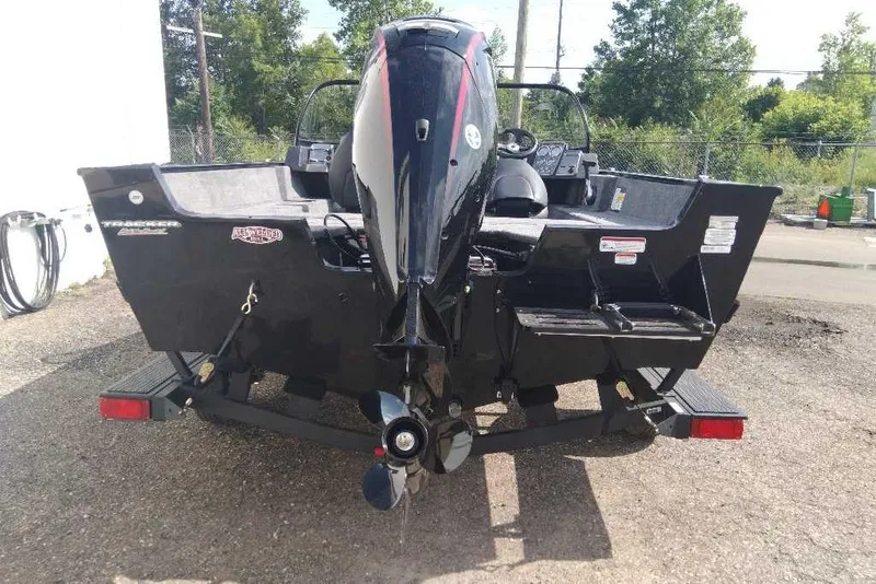 Slide: The Image of 2026 Tracker Pro Guide V-175 Combo boat, rear view with motor, parked outdoors. - 7