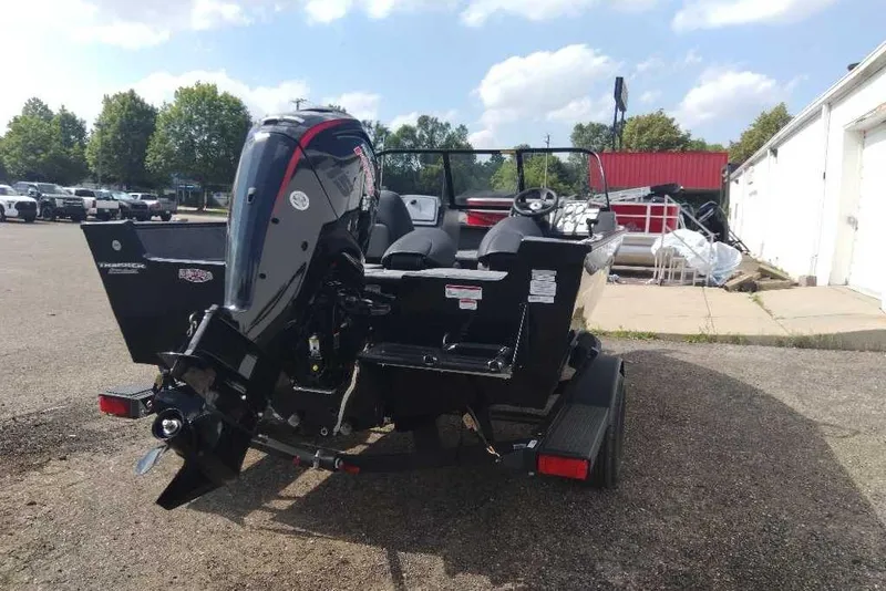 Slide: The Image of 2026 Tracker Pro Guide V-175 Combo boat, rear view, parked outdoors on a sunny day. - 4