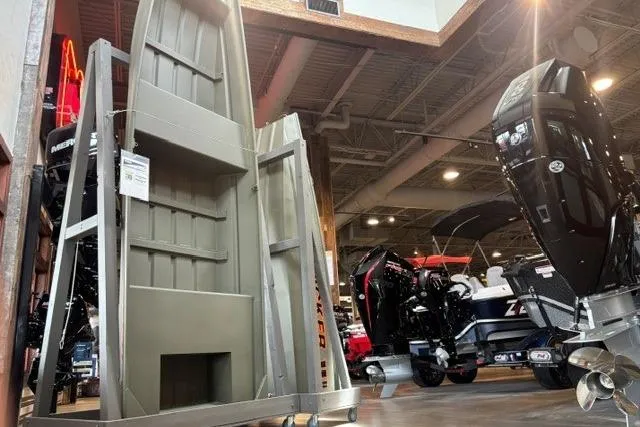 The Image of 2026 Tracker Grizzly 14 Jon boat displayed in showroom with outboard motors. - 0