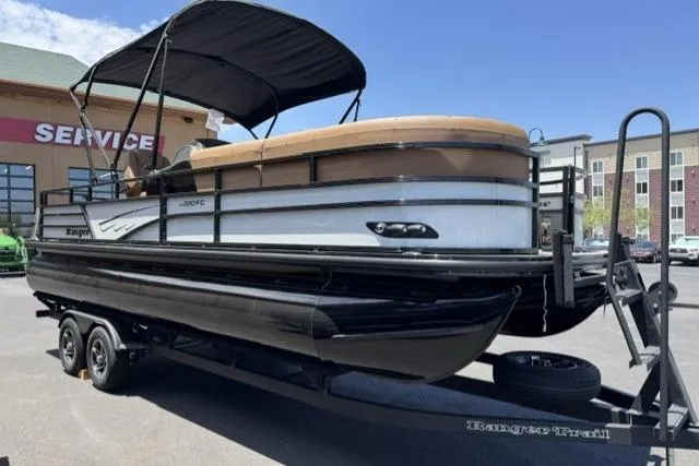 The Image of 2026 Ranger 220FC pontoon boat on trailer, parked near service center. - 0