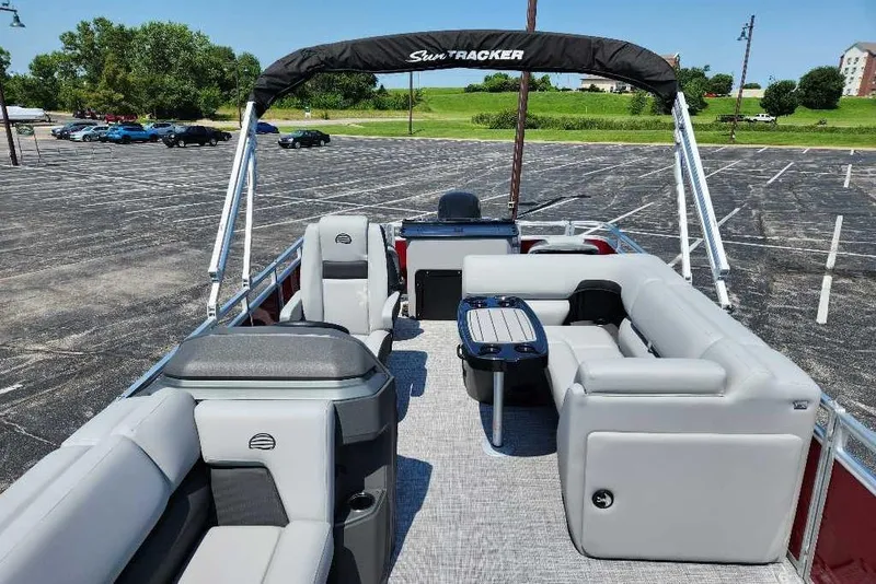 Slide: The Image of 2026 Sun Tracker SportFish 20 DLX pontoon boat with spacious seating and canopy in a parking lot. - 6
