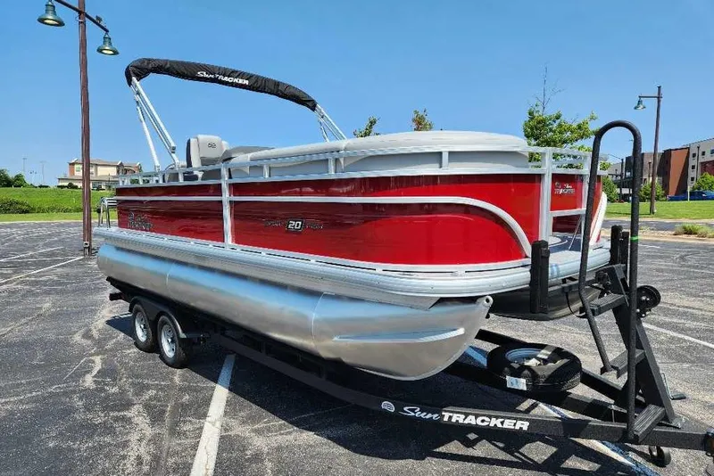 Slide: The Image of 2026 Sun Tracker SportFish 20 DLX pontoon boat on trailer in parking lot. - 2