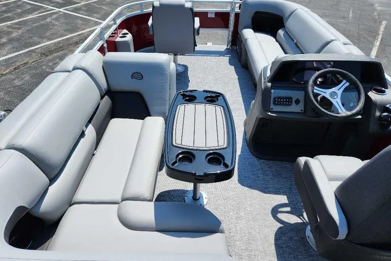 Slide: The Image of 2026 Sun Tracker SportFish 20 DLX pontoon boat interior with plush seating and steering console. - 5