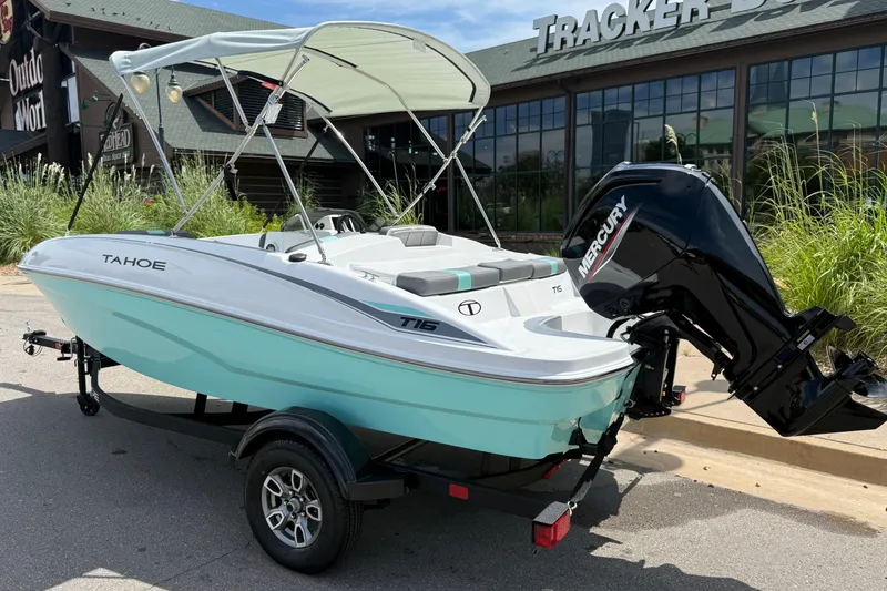 Slide: The Image of 2026 Tahoe T16 boat with Mercury engine, parked outside a store. - 2