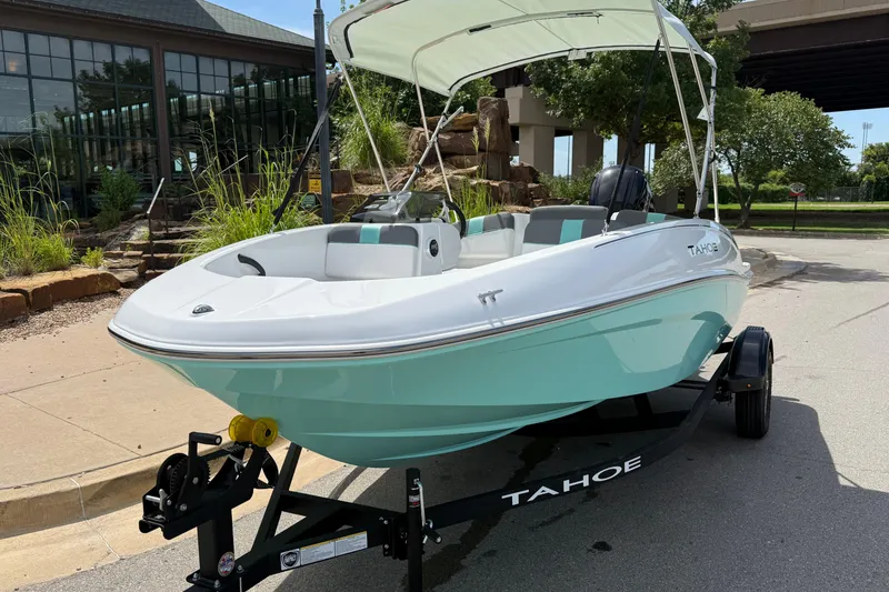 Slide: The Image of 2026 Tahoe T16 boat with canopy on trailer, parked outdoors. - 1