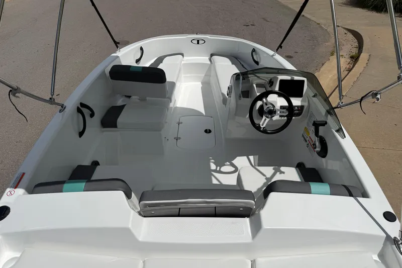 Slide: The Image of 2026 Tahoe T16 boat interior with modern steering and seating, docked on a sunny day. - 4