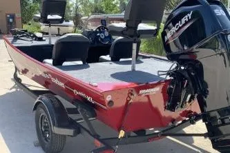 Slide: The Image of 2026 Tracker Bass Tracker Classic XL boat with Mercury engine, parked outdoors. - 2