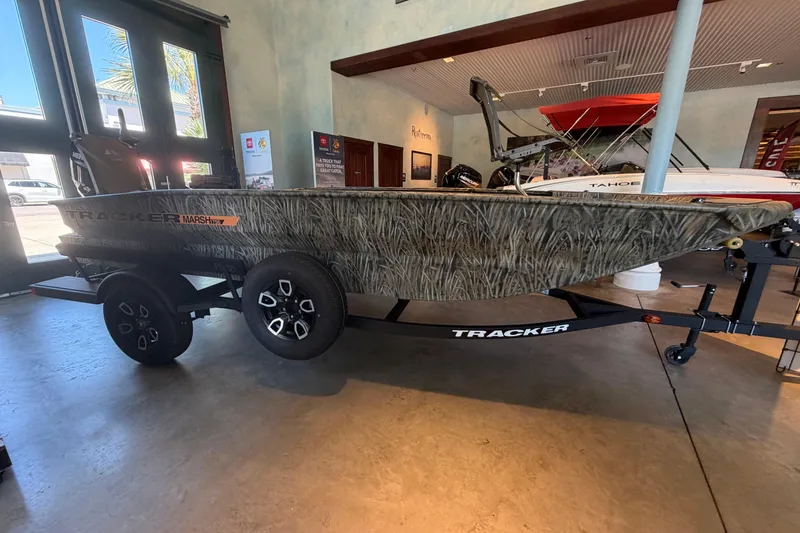 The Image of 2026 Tracker Grizzly 1756 T Marsh boat in showroom, camouflage design, on trailer. - 0