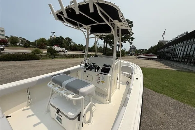 Slide: The Image of 2026 Mako 214 Center Console boat with T-top and seating, parked outdoors. - 13