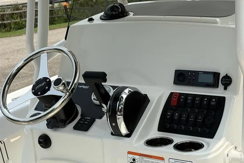 Slide: The Image of 2026 Mako 214 Center Console boat dashboard with steering wheel and control panel. - 12