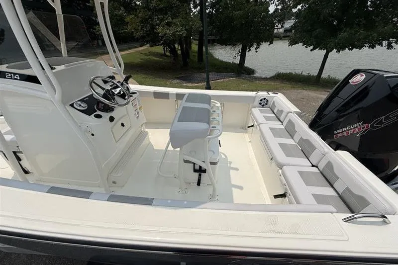 Slide: The Image of 2026 Mako 214 Center Console boat with spacious seating and modern controls by the water. - 15