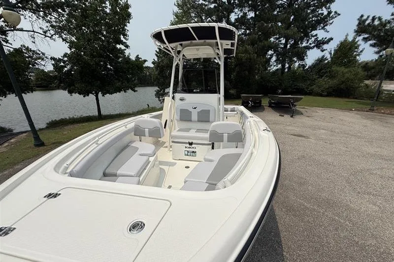 Slide: The Image of 2026 Mako 214 Center Console boat parked near a serene lake. - 9
