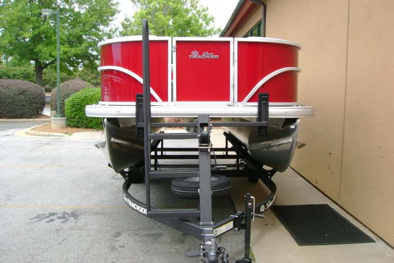 Slide: The Image of 2026 Sun Tracker Party Barge 16 DLX pontoon boat on trailer, vibrant red exterior. - 3