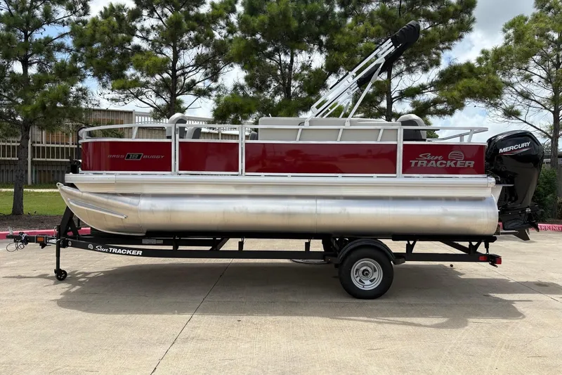 The Image of 2026 Sun Tracker Bass Buggy 18 DLX pontoon boat on trailer, parked outdoors. - 0