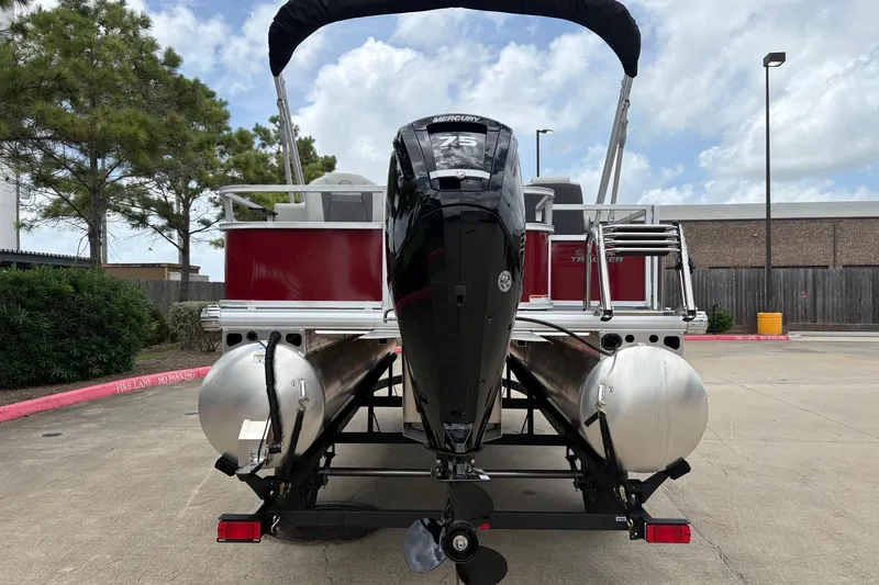 Slide: The Image of 2026 Sun Tracker Bass Buggy 18 DLX pontoon boat with Mercury 75 engine, parked outdoors. - 7