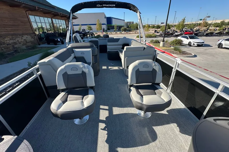 Slide: The Image of 2026 Sun Tracker Fishin' Barge 22 DLX pontoon boat interior with seating and helm. - 16