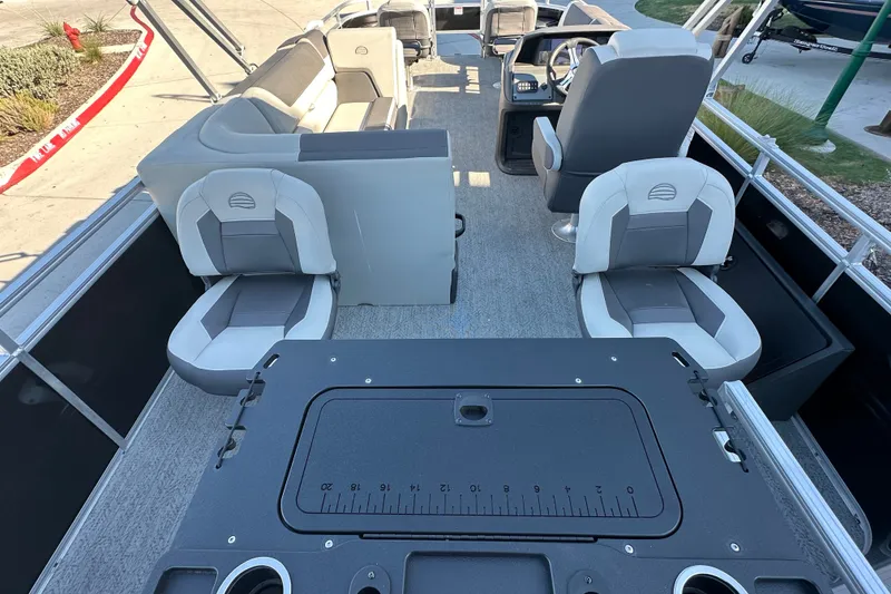 Slide: The Image of 2026 Sun Tracker Fishin' Barge 22 DLX interior with seating and helm station. - 24