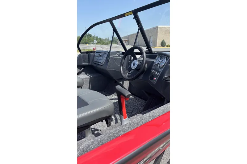 Slide: The Image of Interior view of 2026 Tracker Pro Guide V-16 WT boat, featuring steering wheel and dashboard controls. - 4