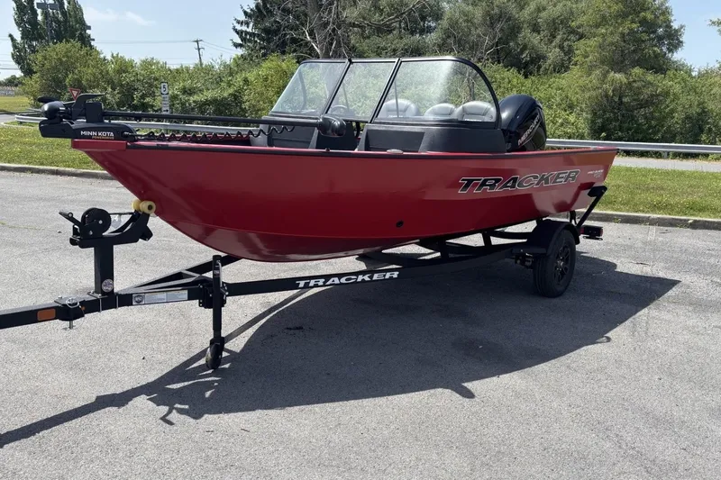 The Image of Red 2026 Tracker Pro Guide V-16 WT boat on trailer, parked outdoors. - 0