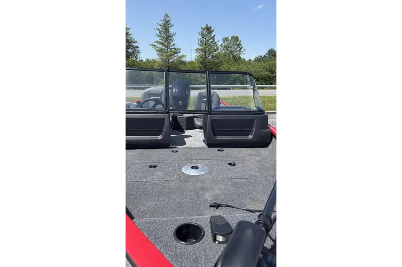 Slide: The Image of 2026 Tracker Pro Guide V-16 WT boat interior with windshield and seating, outdoors. - 2