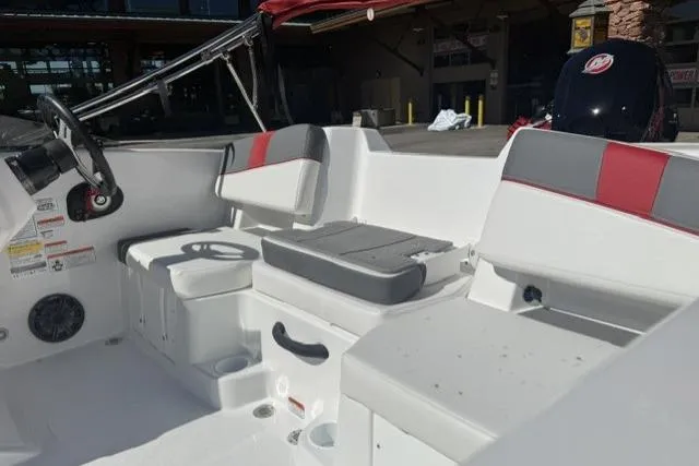 Slide: The Image of 2026 Tahoe T18 boat interior with white and red seating, steering wheel, and cup holders. - 7