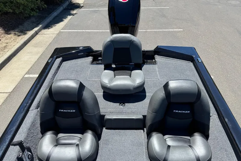 Slide: The Image of 2026 Tracker Pro Team 190 boat interior with three black seats in a parking lot. - 11