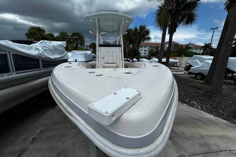 Slide: The Image of 2025 Ranger 2600 Bay boat on display, surrounded by palm trees and covered boats. - 4