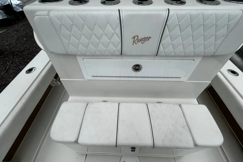 Slide: The Image of 2025 Ranger 2600 Bay boat interior with white quilted seating and storage compartment. - 11