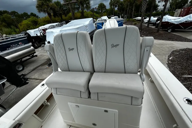 Slide: The Image of 2025 Ranger 2600 Bay boat with dual cushioned seats, parked outdoors. - 8