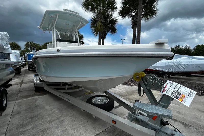 Slide: The Image of 2025 Ranger 2600 Bay boat on trailer, parked outdoors under cloudy sky. - 3