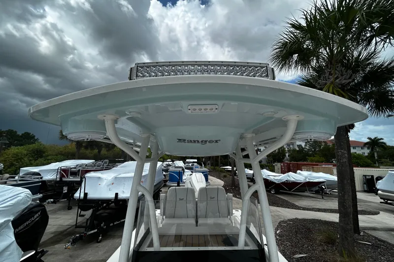 Slide: The Image of 2025 Ranger 2600 Bay boat with T-top, parked outdoors under cloudy sky. - 14