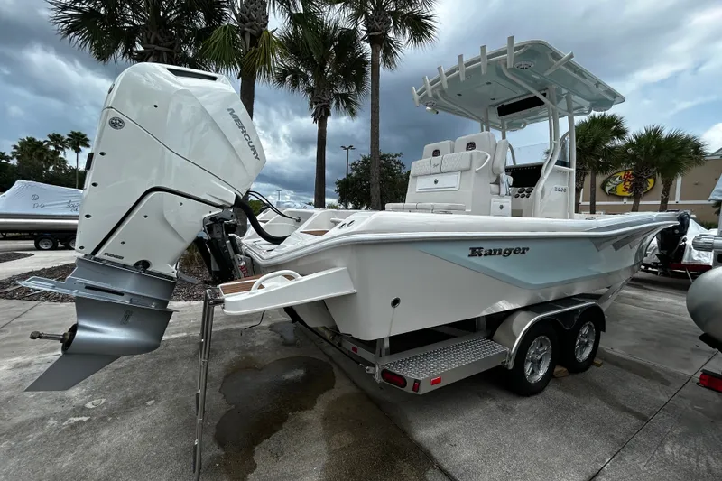 Slide: The Image of 2025 Ranger 2600 Bay boat with Mercury engine on trailer, parked outdoors. - 2