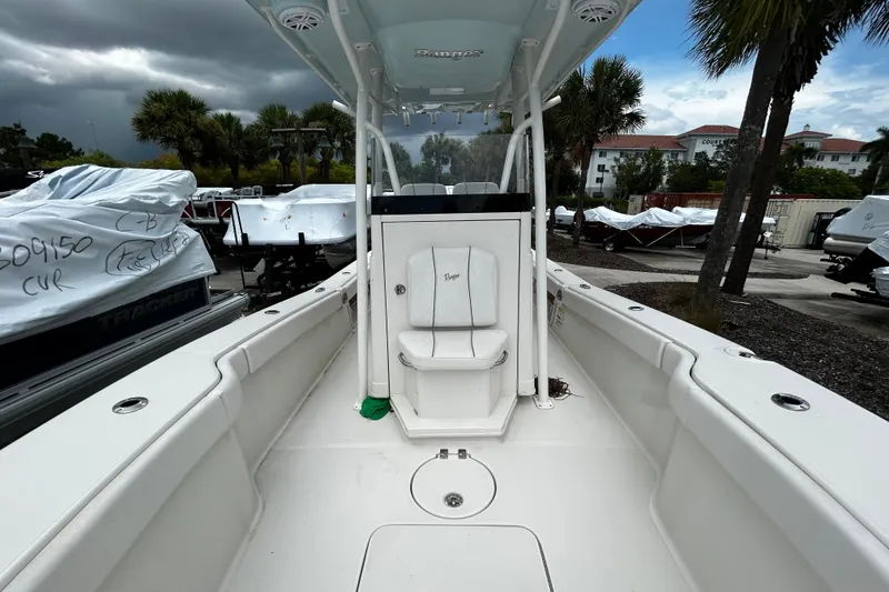 Slide: The Image of 2025 Ranger 2600 Bay boat interior with center console and seating, parked outdoors. - 6