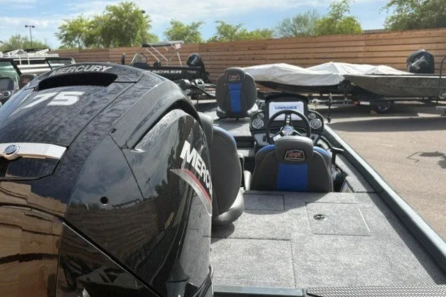 Slide: The Image of 2026 Ranger RT178 boat with Mercury engine, parked outdoors, showcasing interior and controls. - 2