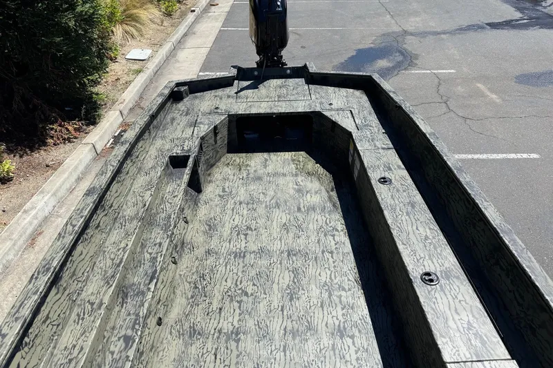 Slide: The Image of 2026 Tracker Grizzly 1756 T Marsh boat with camouflage design in a parking lot. - 8