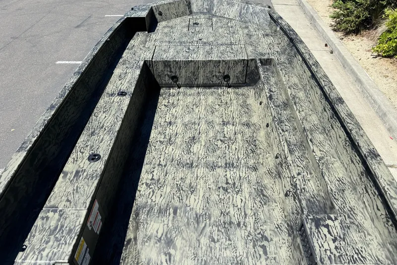 Slide: The Image of 2026 Tracker Grizzly 1756 T Marsh boat with camouflage pattern, parked on pavement. - 7