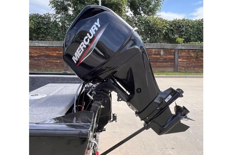 Slide: The Image of Outboard motor on 2026 Tracker Super Guide V-16 SC boat, parked outdoors. - 4